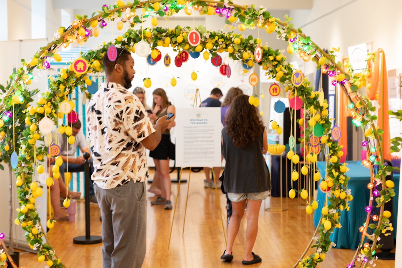 Attendees stepping through the lemon arch onto the midway