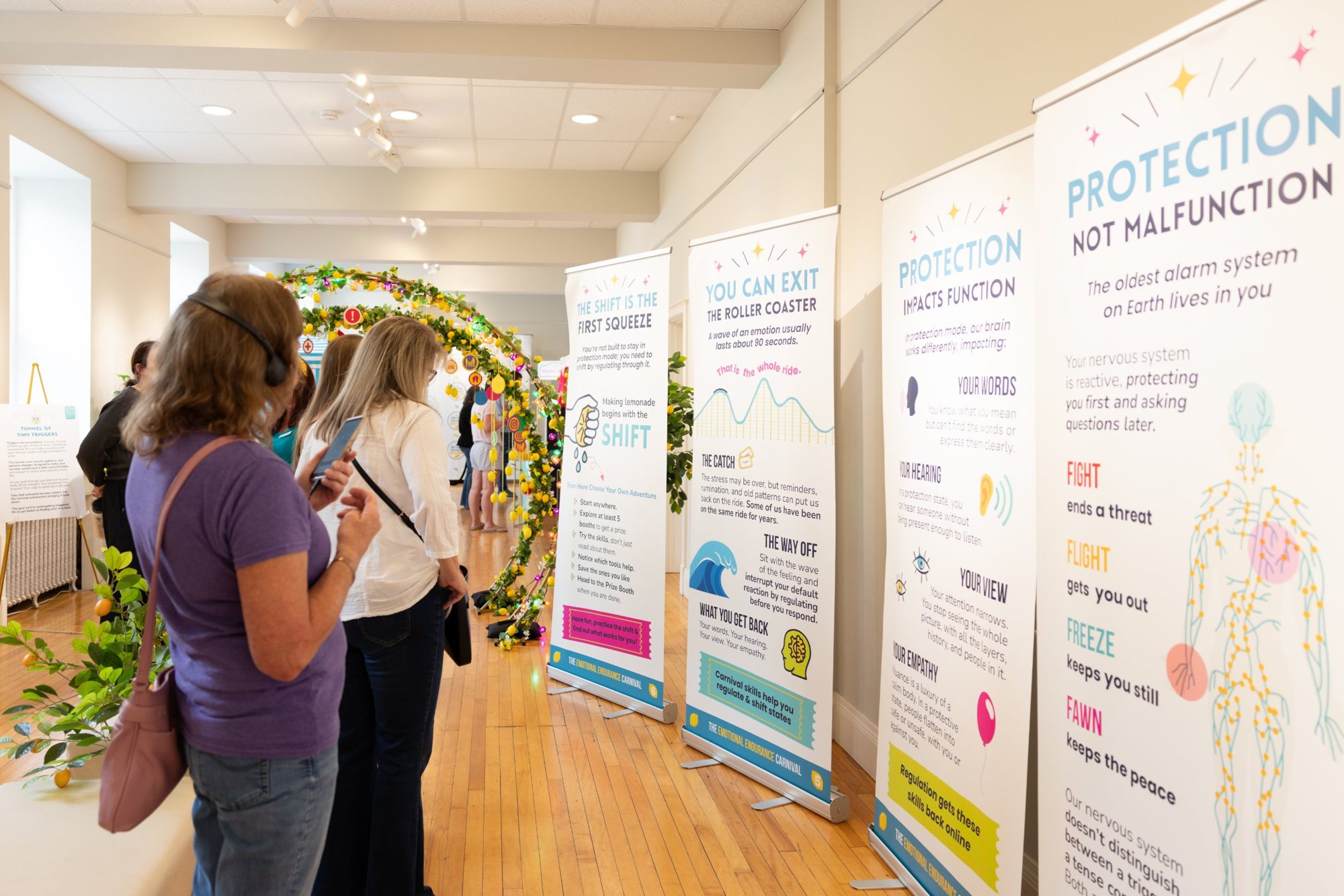 Attendees reading the Carnival teaching banners beside the lit lemon arch